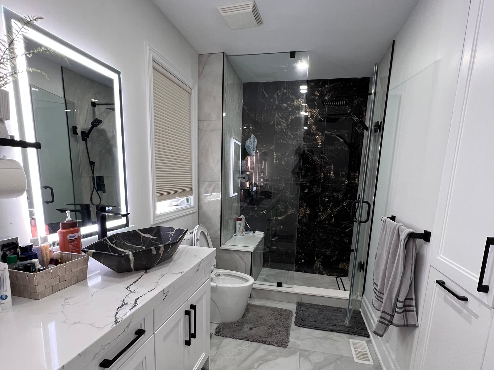 Bathroom with vanity cabinetry, vessel basins, lit mirrors and a glass shower enclosure — from the October 2026 catalogue