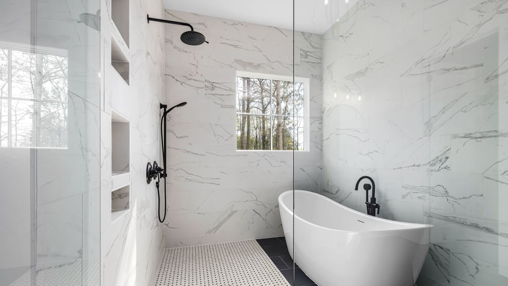 Luxury bathroom with a freestanding tub, white marble walls, a walk-in shower with black fixtures and a window — a licensed illustrative photograph, not a Prime Kitchen and Bath project