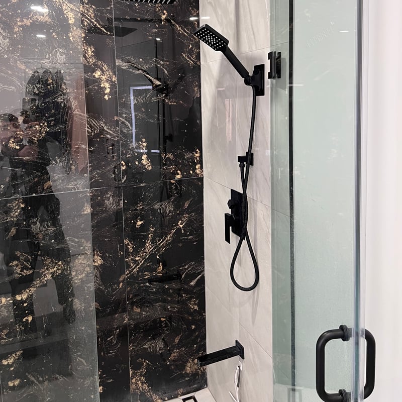 Shower with black marble-look porcelain walls, matte black fixtures and a rain head