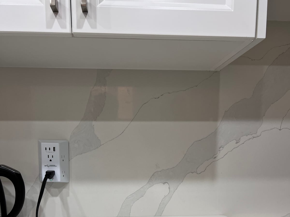 Quartz countertop edge meeting the veined backsplash
